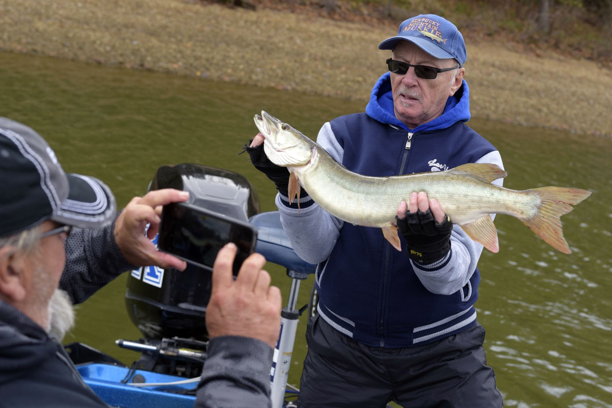 Louie Friedman shows off his catch, a 30-inch muskellunge, known locally as "muskie." Louie's guide and friend of 20 years, Tony Grant, captures a few photos before the fish is released back into the water. While anglers in Kentucky can legally keep any muskie over 30 inches, Tony's entire operation is catch-and-release. "We'd be blackballed if it got out that we let someone take a fish out of this lake," he says.