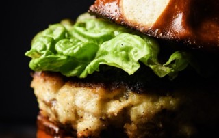 Redfish burgers with red onion, leaf lettuce and a pretzel bun