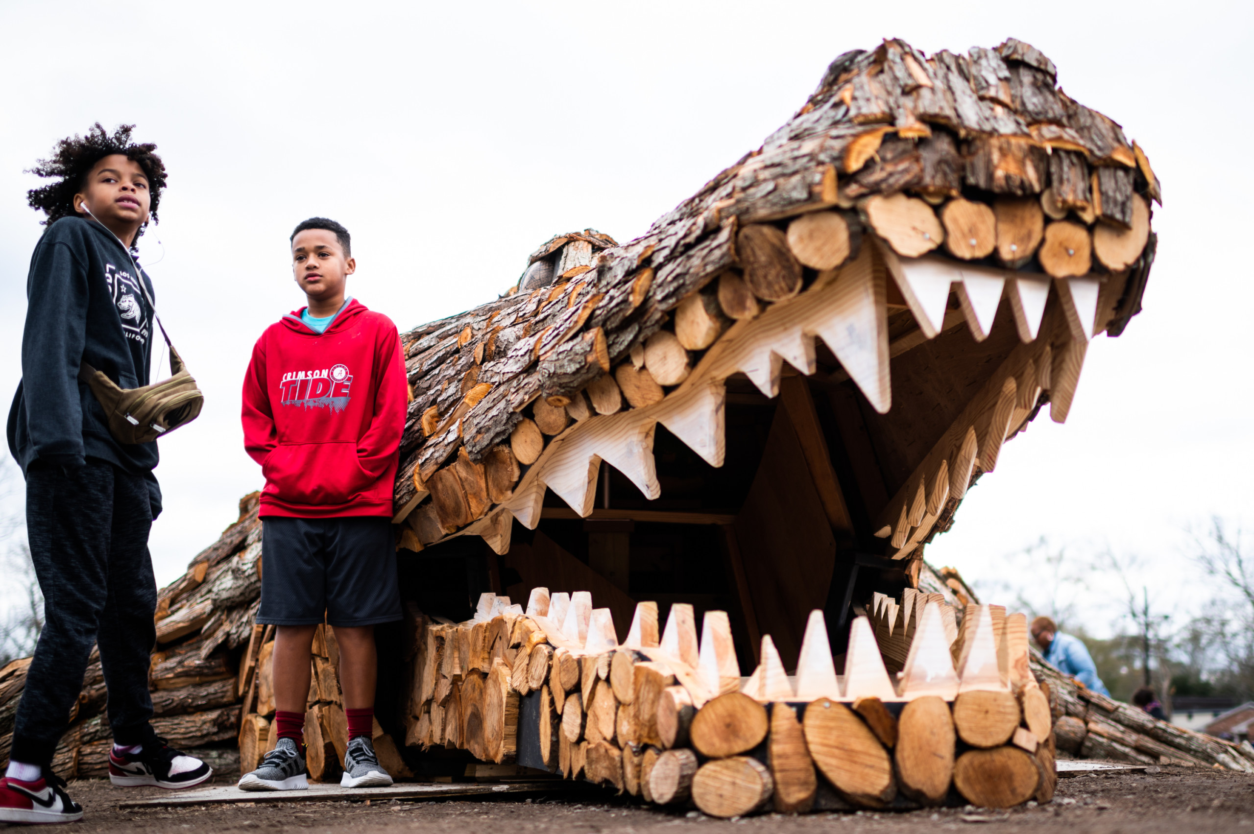 Kids pose in front of the mouth of the sculpture for a quick photo