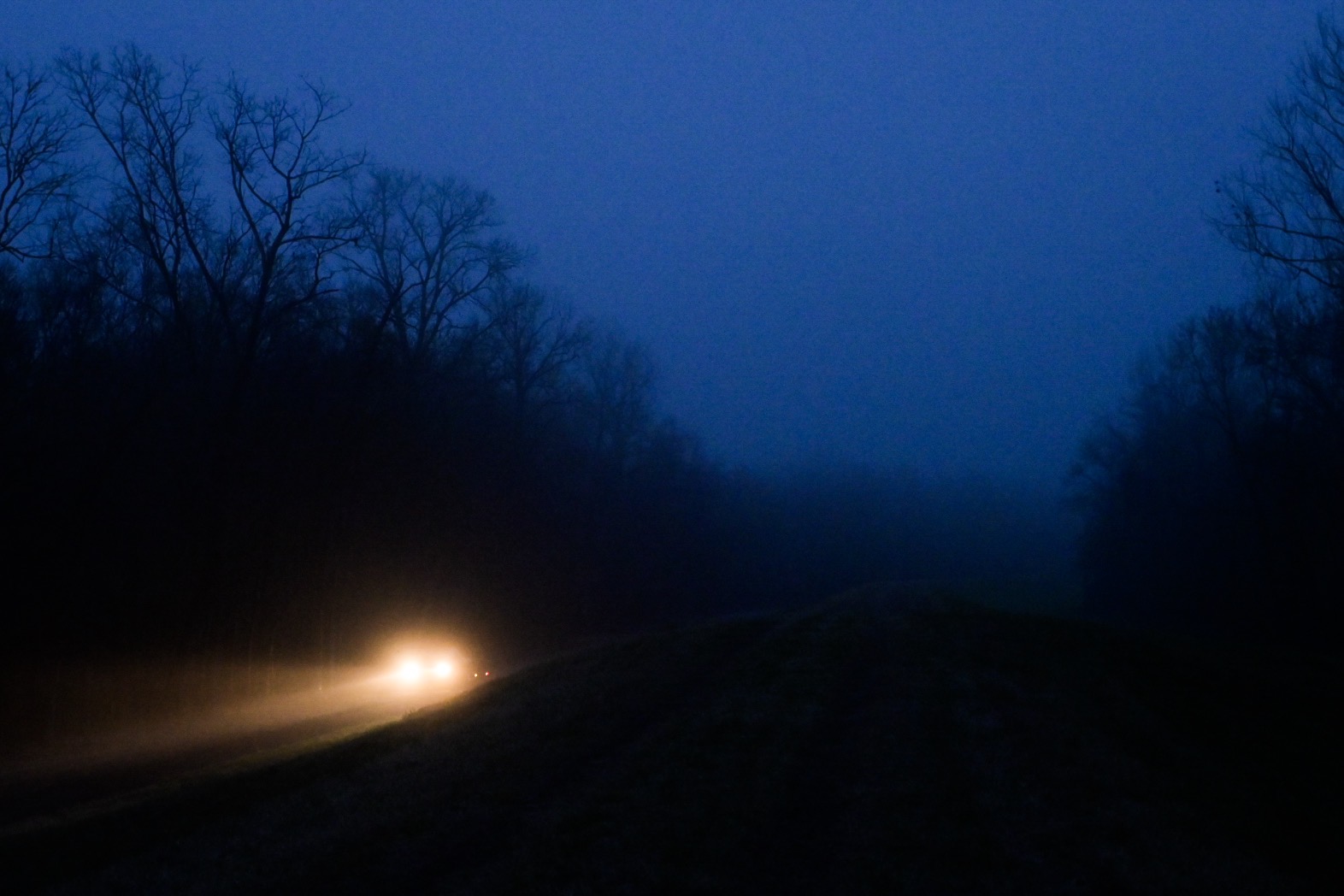 Headlights in the fog before sunrise near Henderson, Louisiana