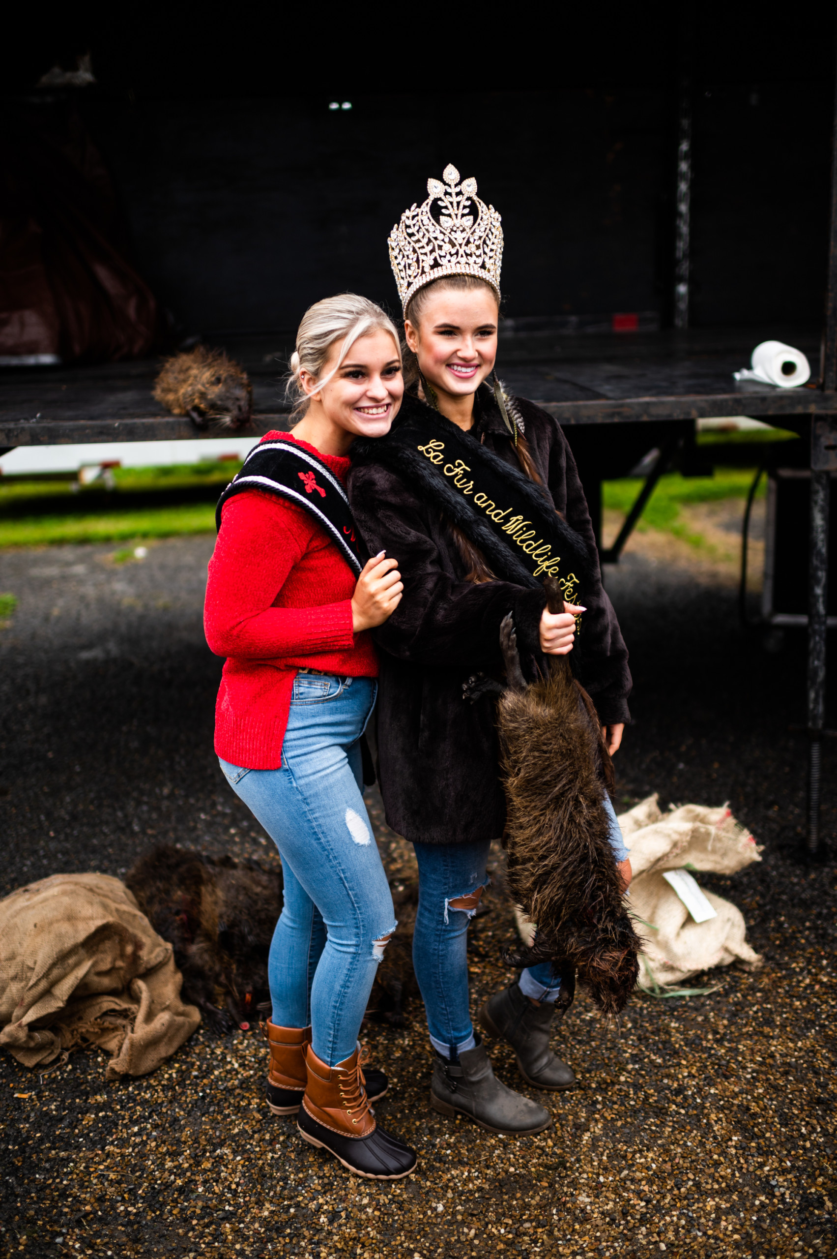 Festival queens pose with a recently killed nutria at the Fur & Wildlife Festival