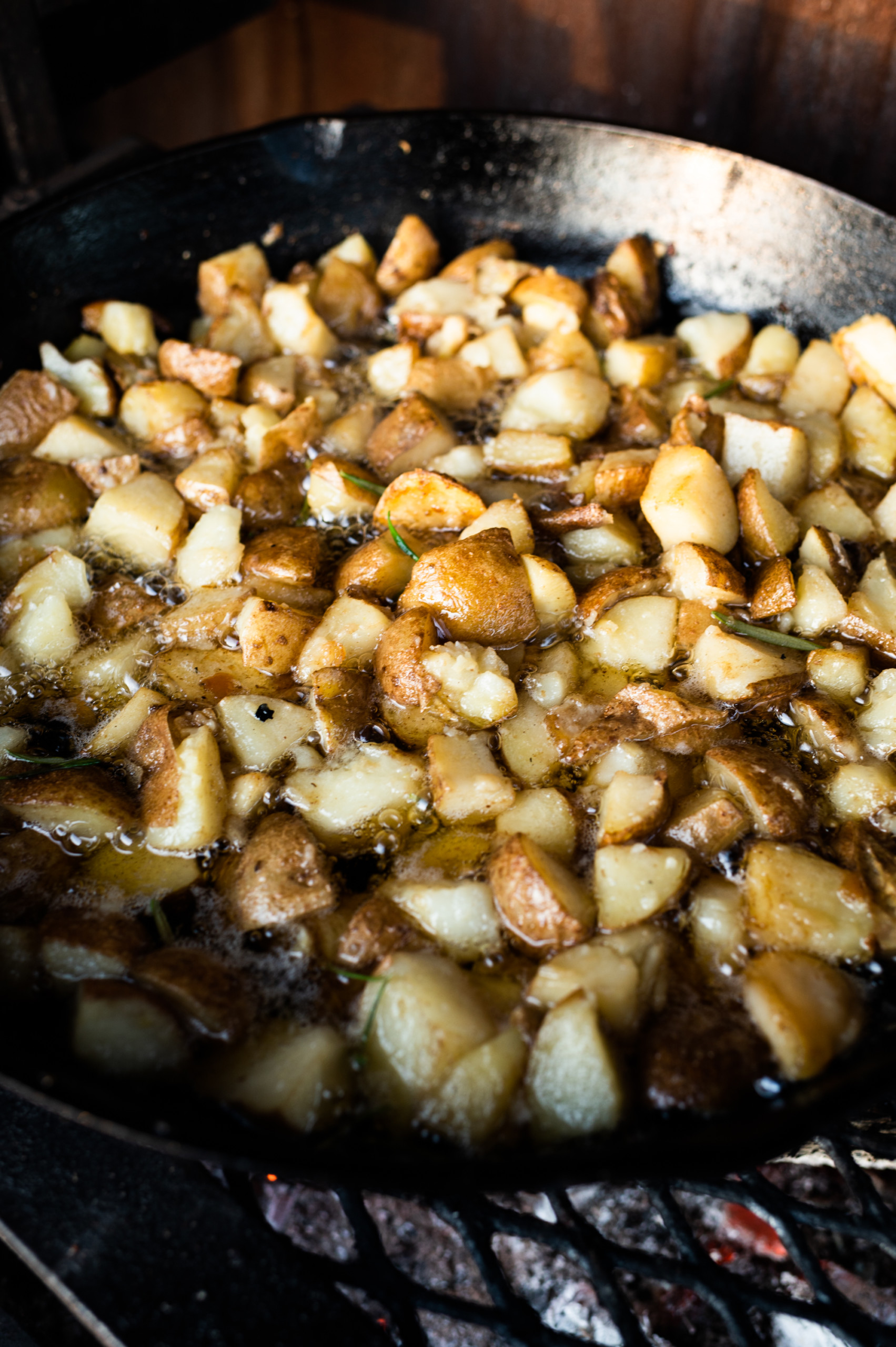 Potatoes frying in pork fat over an open fire