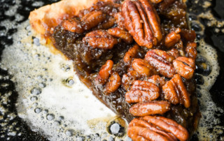 Bourbon pecan pie in a pan with hot butter