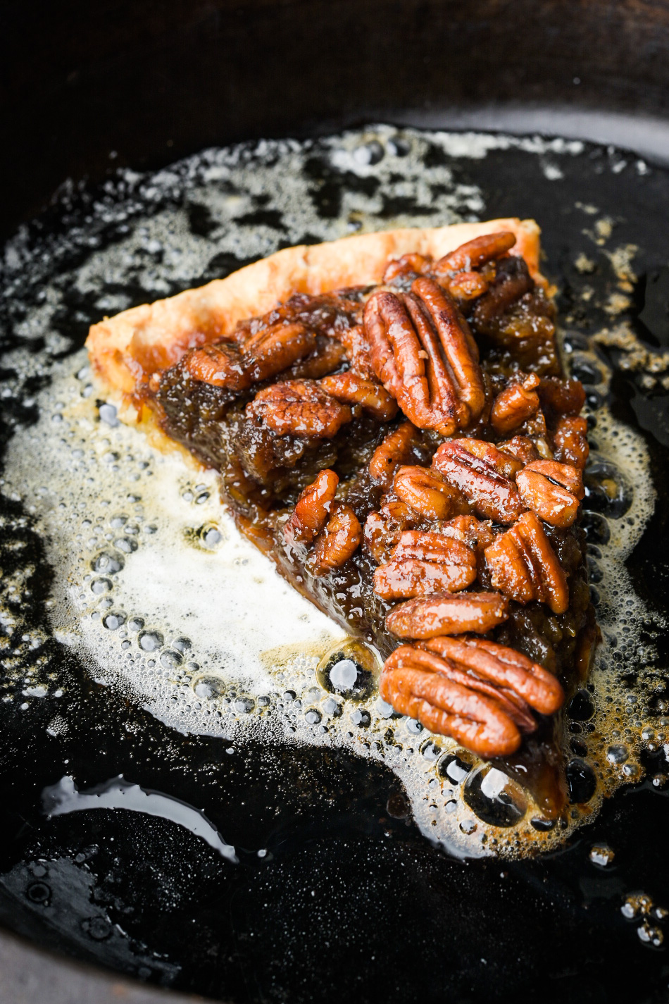 Bourbon pecan pie in a pan with hot butter