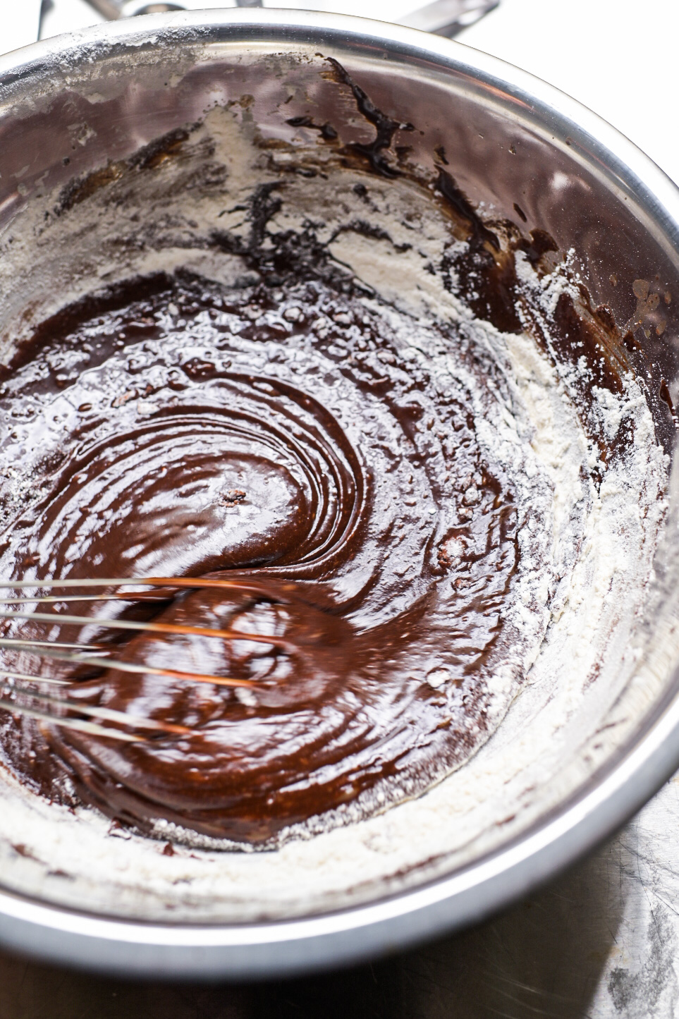 Dry ingredients are whisked in to the melted chocolate and olive oil