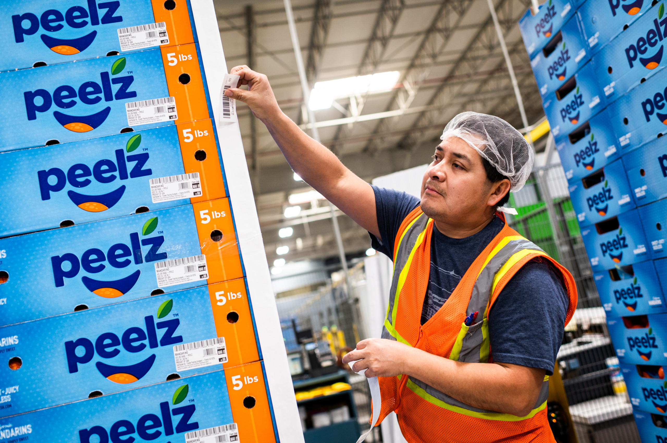 An employee prepares pallets for storage