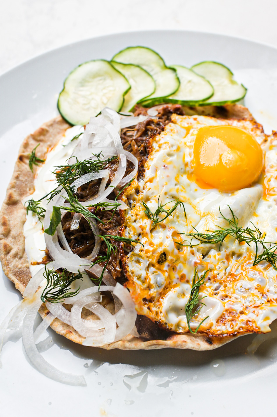 Braised lamb neck roti with a chili oil fried egg