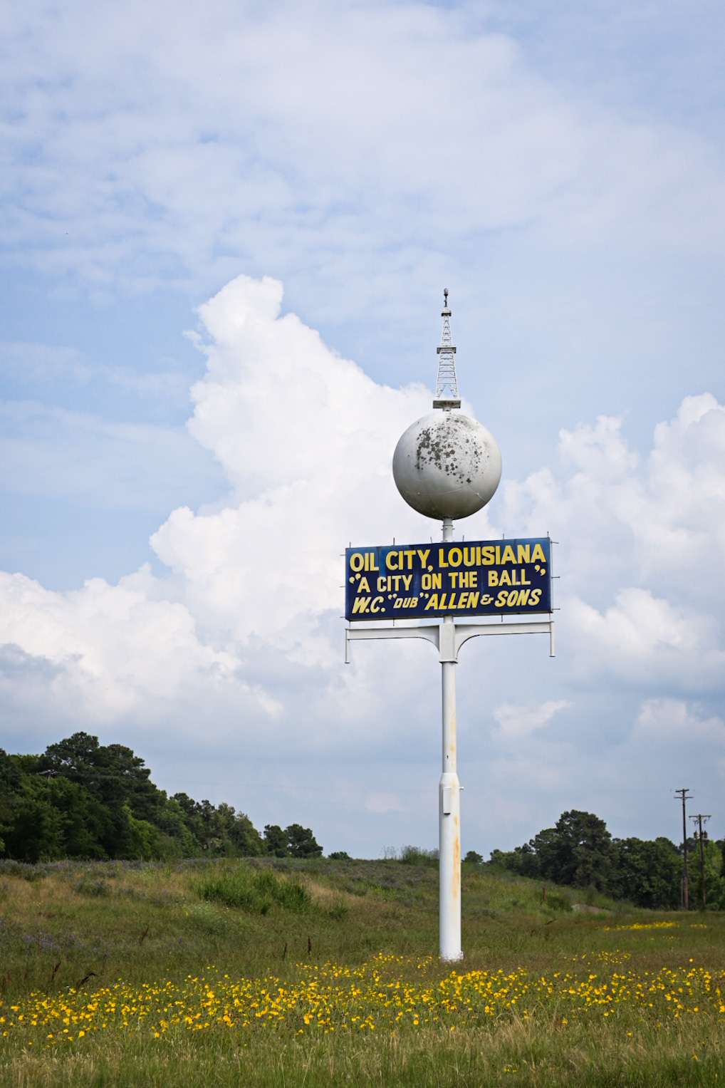 A weathered petroleum service sign greets drivers passing through Oil City, Louisiana