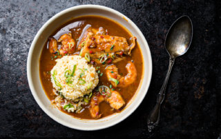 Seafood couvillion with redfish, gulf shrimp, and crab fat butter rice