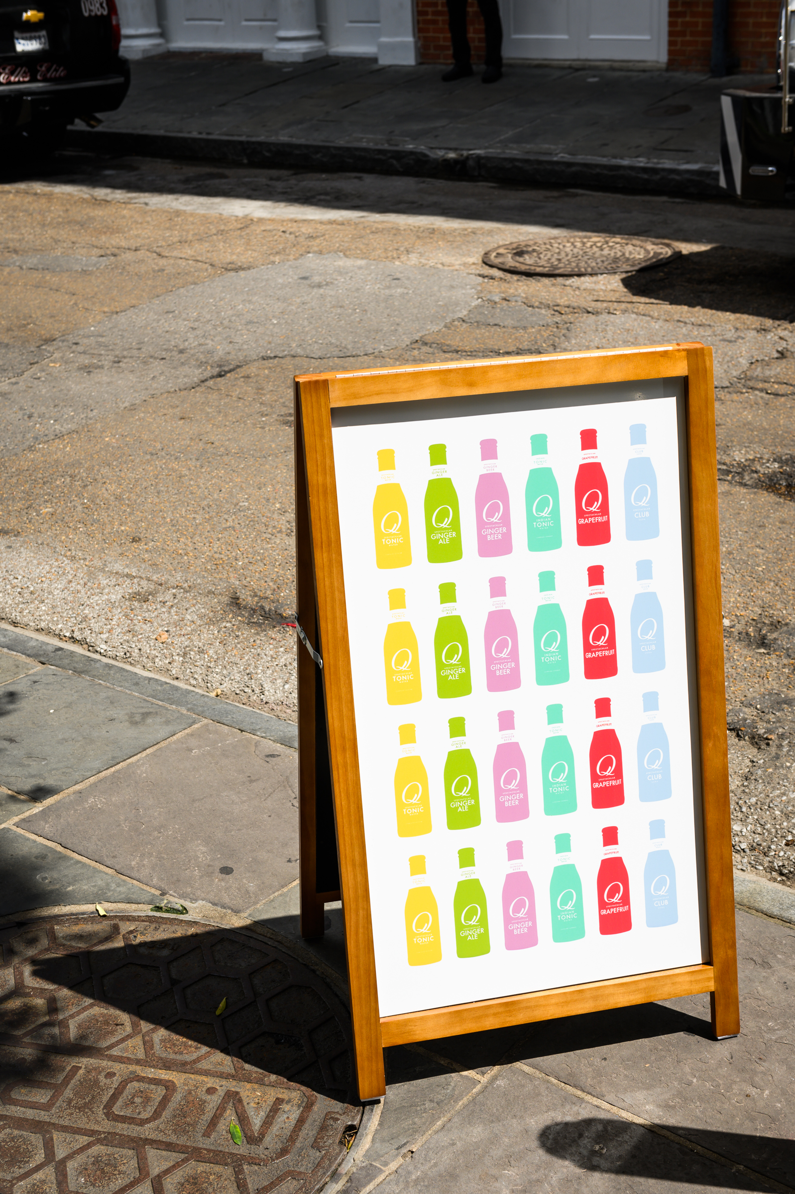 A custom sandwich board promoting Q Mixers in the French Quarter