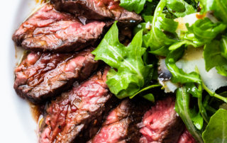 Sliced hanger steak with sea salt, and arugula salad