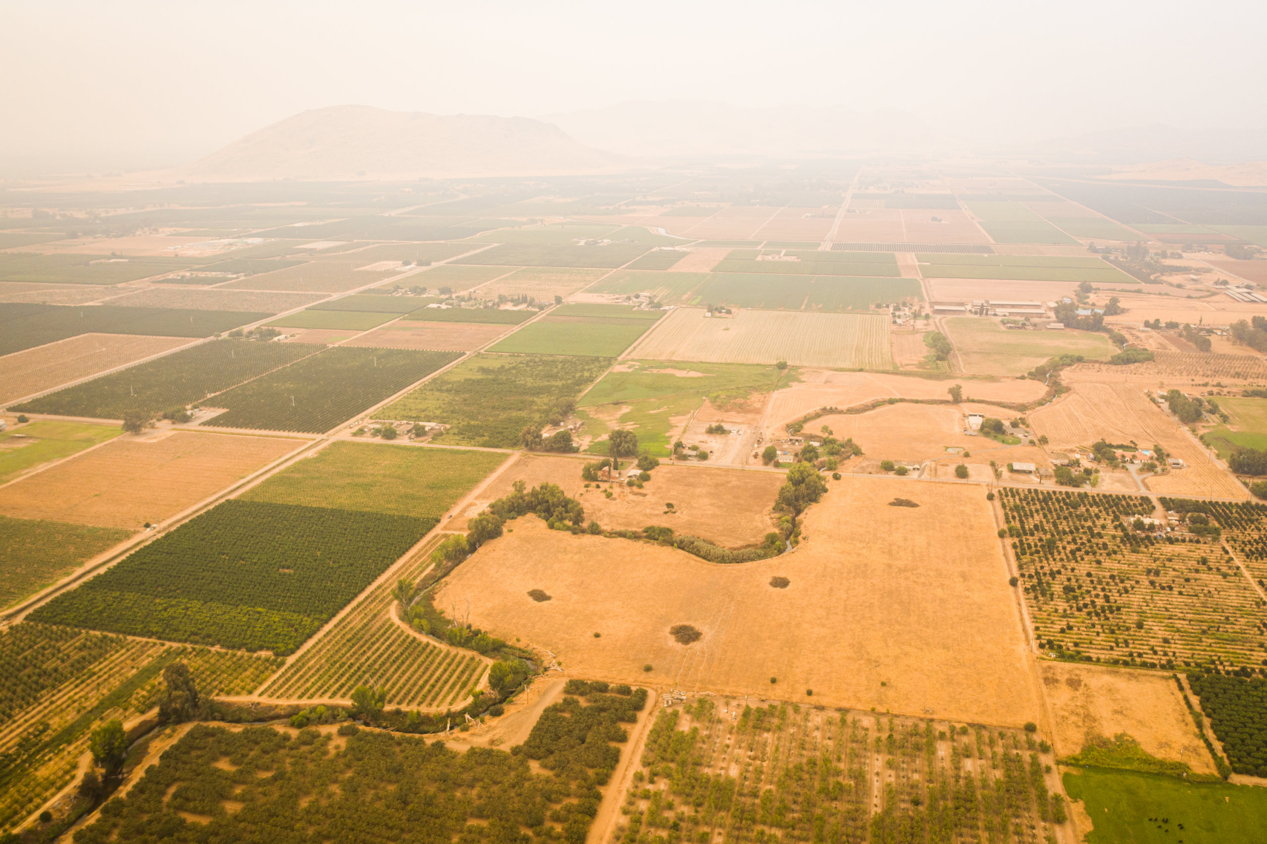 Farms in grids surrounding a river running through the eastern San Joaquin Valley