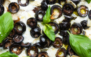 California Ripe Olives baked with cheese and olive oil on a pizza