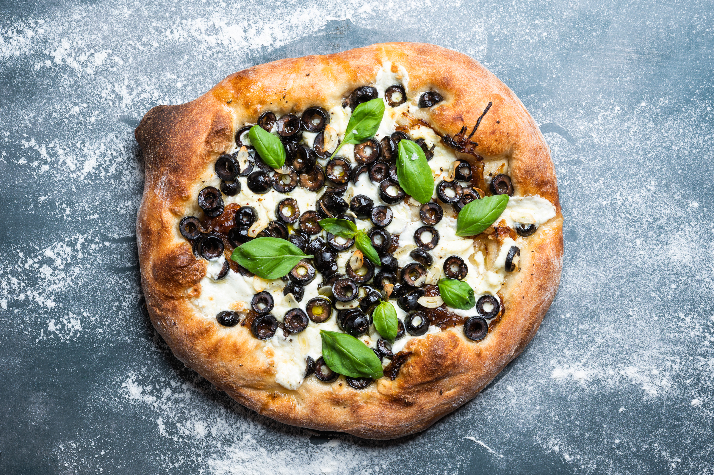 Homemade pizza with olives, cheese, and caramelized onion