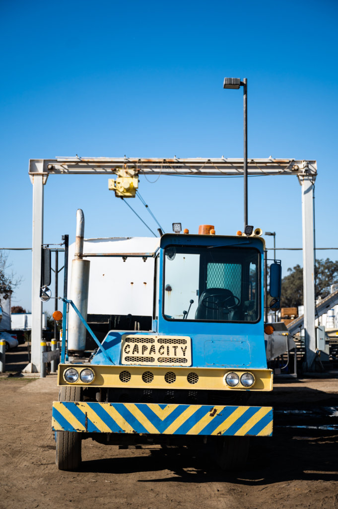 A farm truck pulling a trailer load of olives is unloaded at the mill
