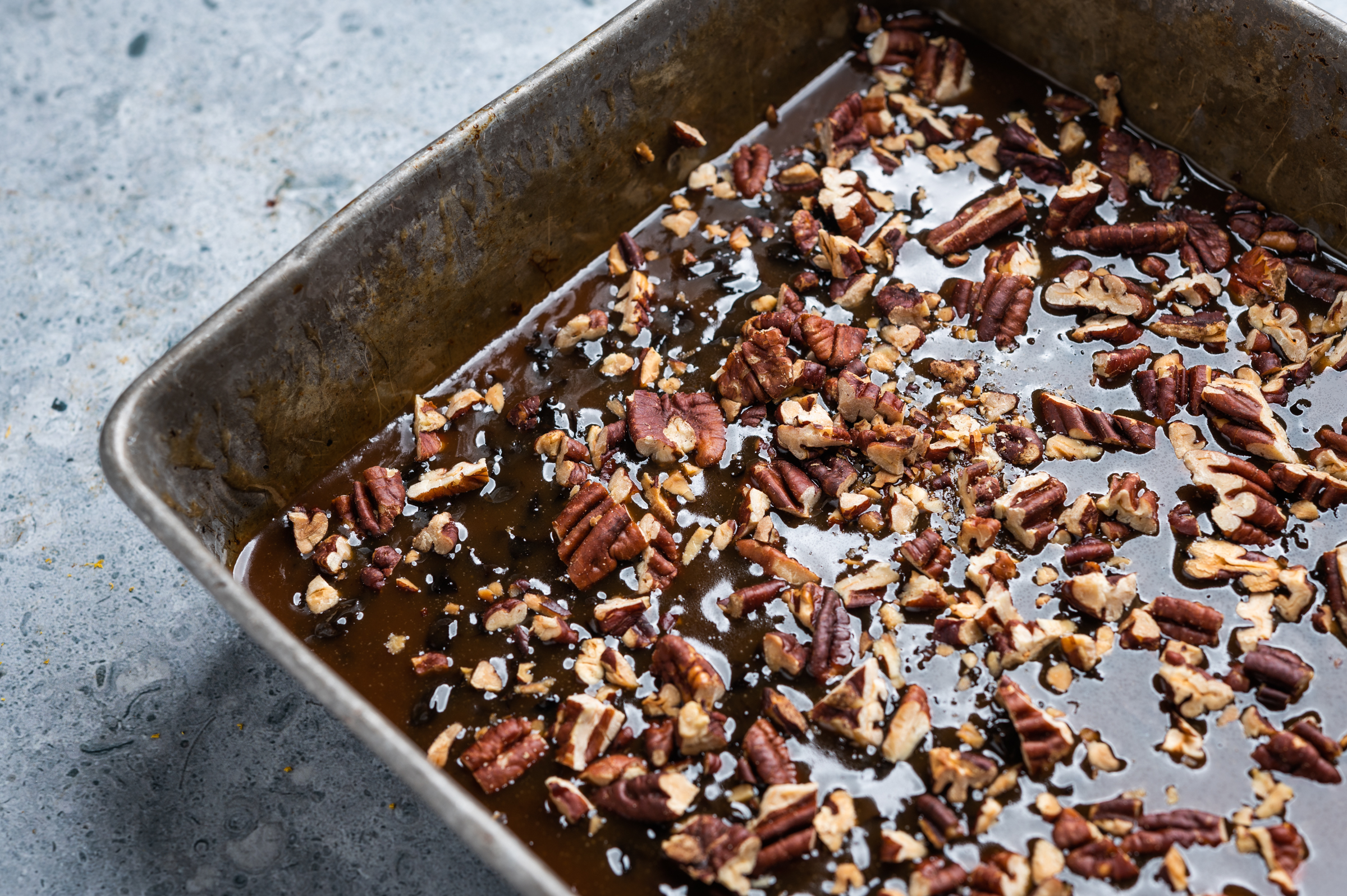 A layer of sticky topping with pecans coats the pan