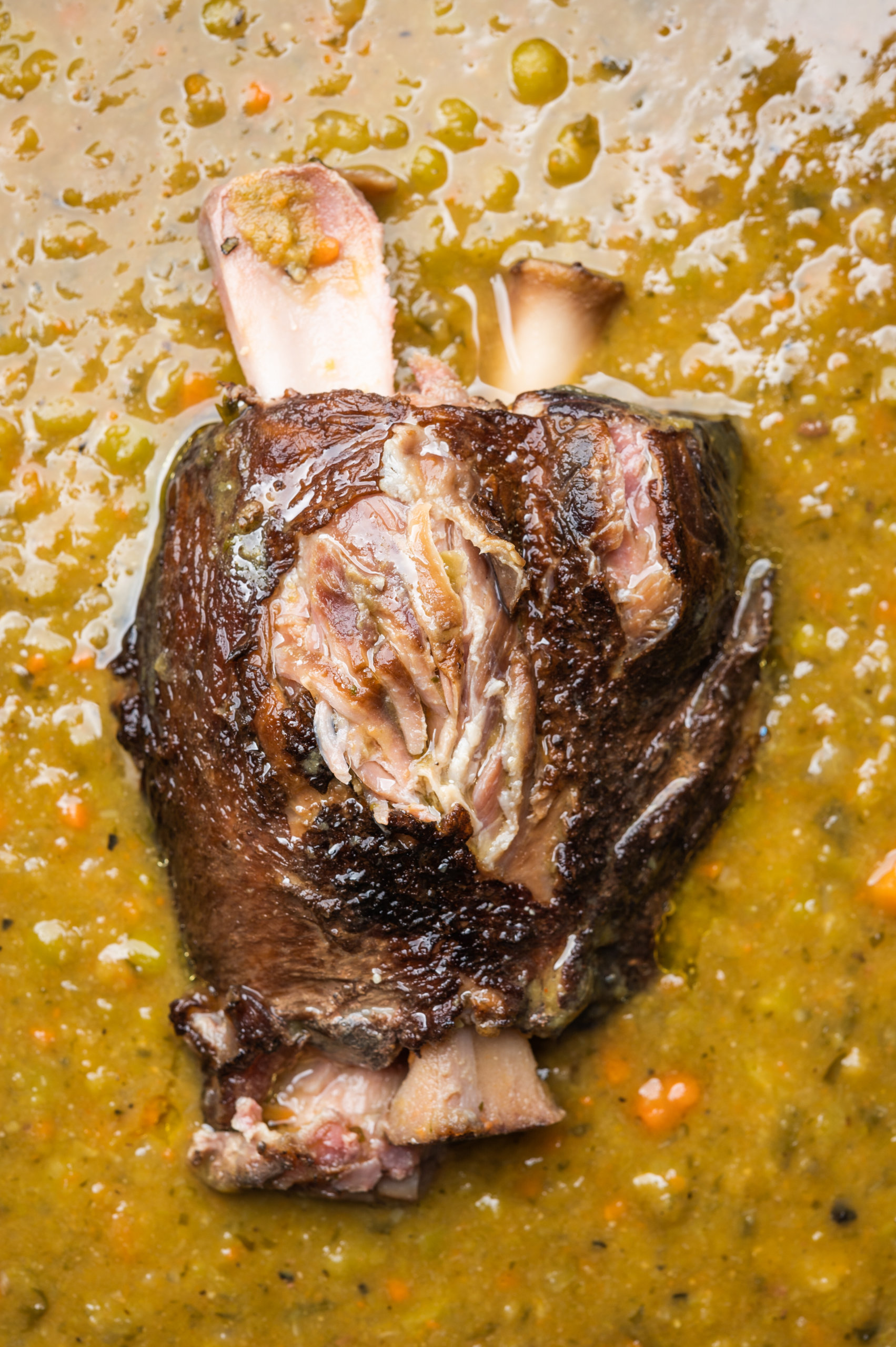 A tender ham shank nestled in a Dutch oven filled with split pea soup