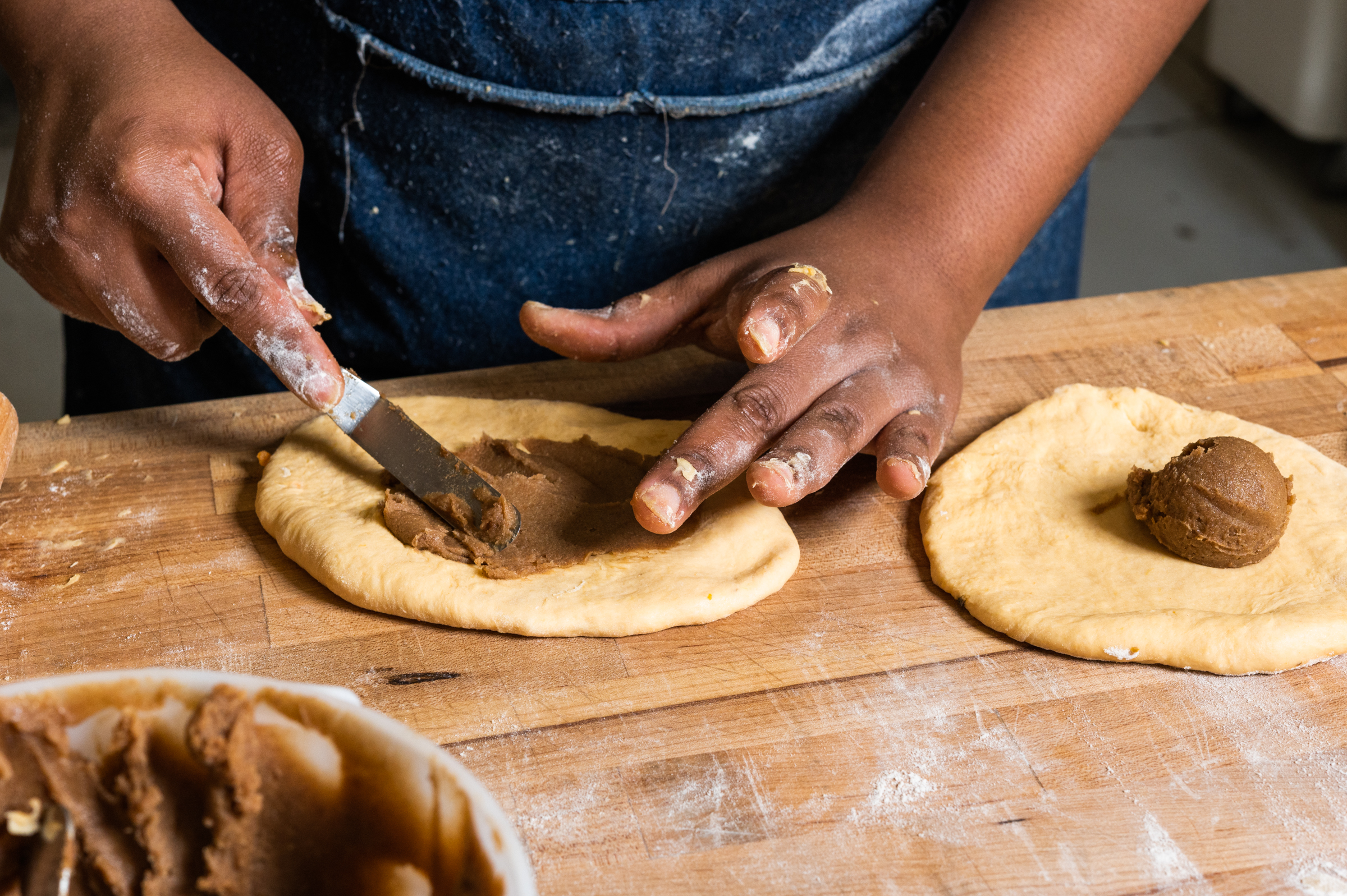 After proofing, the dough is rolled flat and filled with a mixture of brown sugar and spice