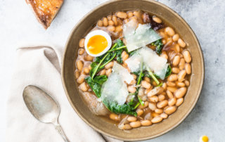 Brothy great northern beans with mustard greens and a jammy egg