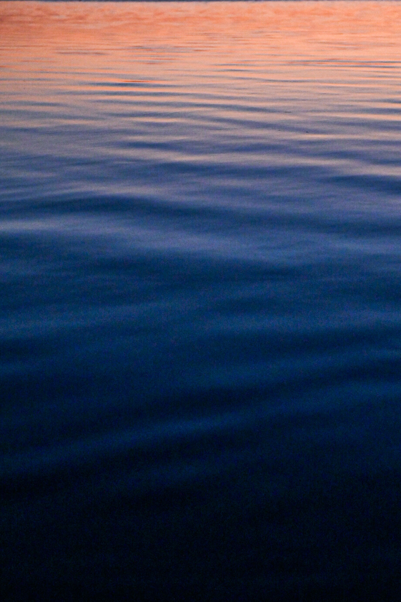 Orange light from sunrise reflected across the water in Reggio