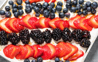 Cracker pie with fresh whipped cream and mixed berries, drizzled with honey