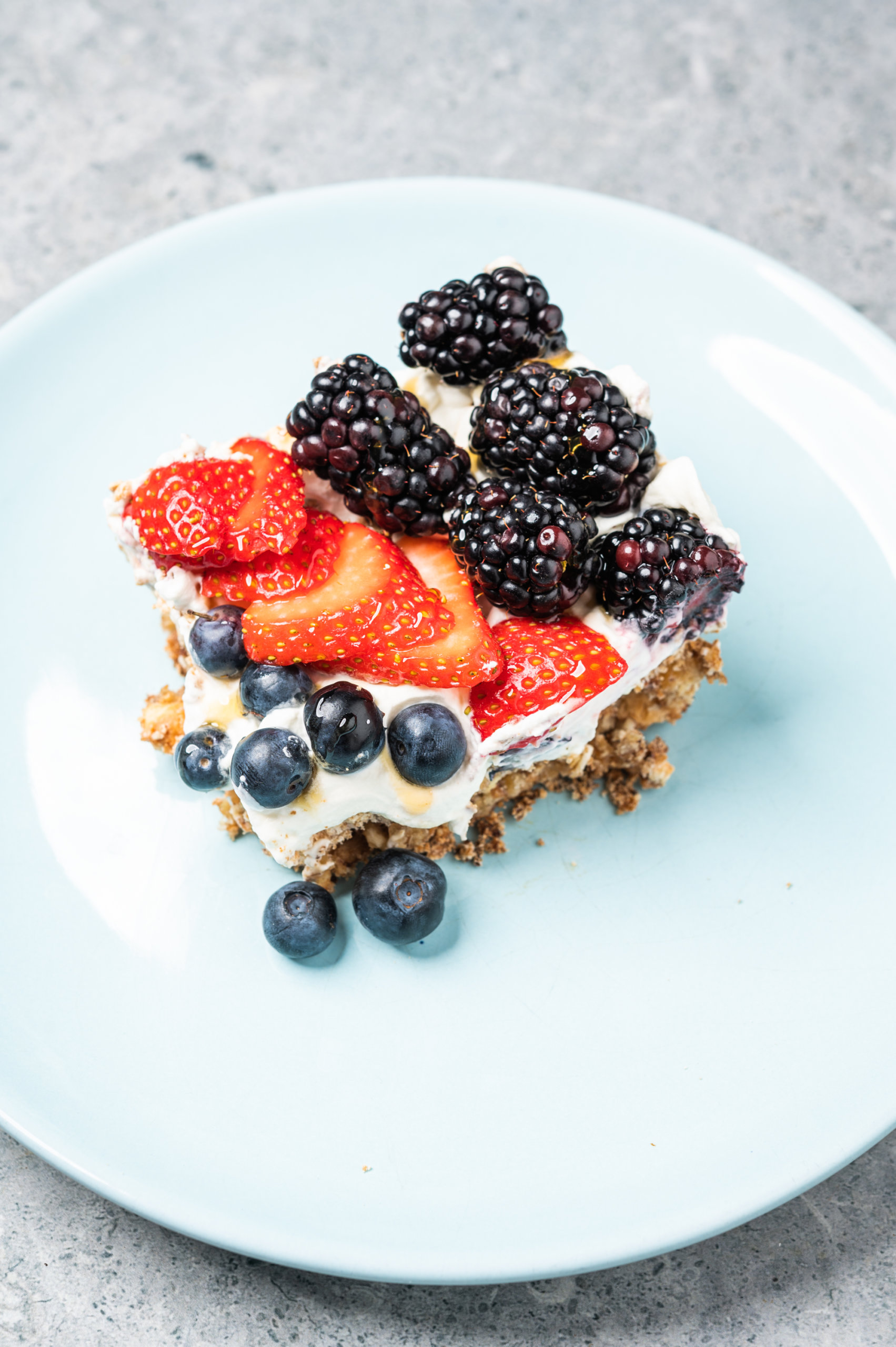 Slice of cracker pie with a saltine and meringue crust and fresh strawberries and blackberries