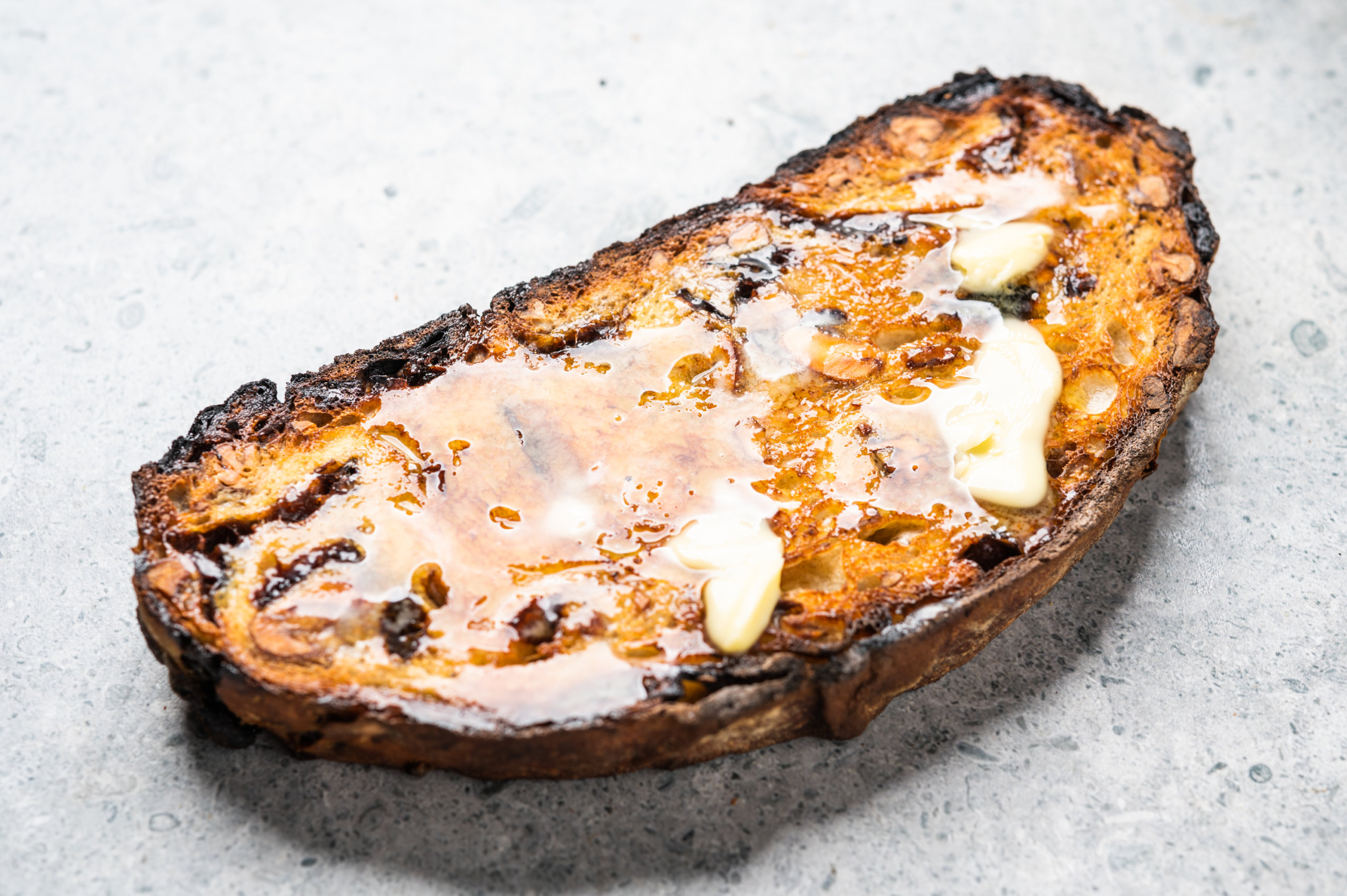 Butter melting on toasted prune and cardamom bread