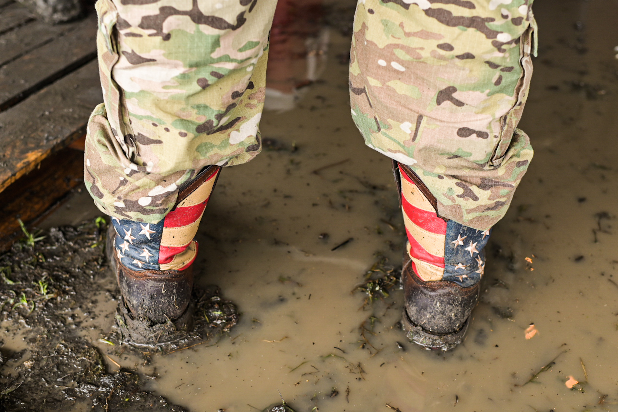 Boots ankle-deep in mud and rainwater in the Hog Dat Nation tent