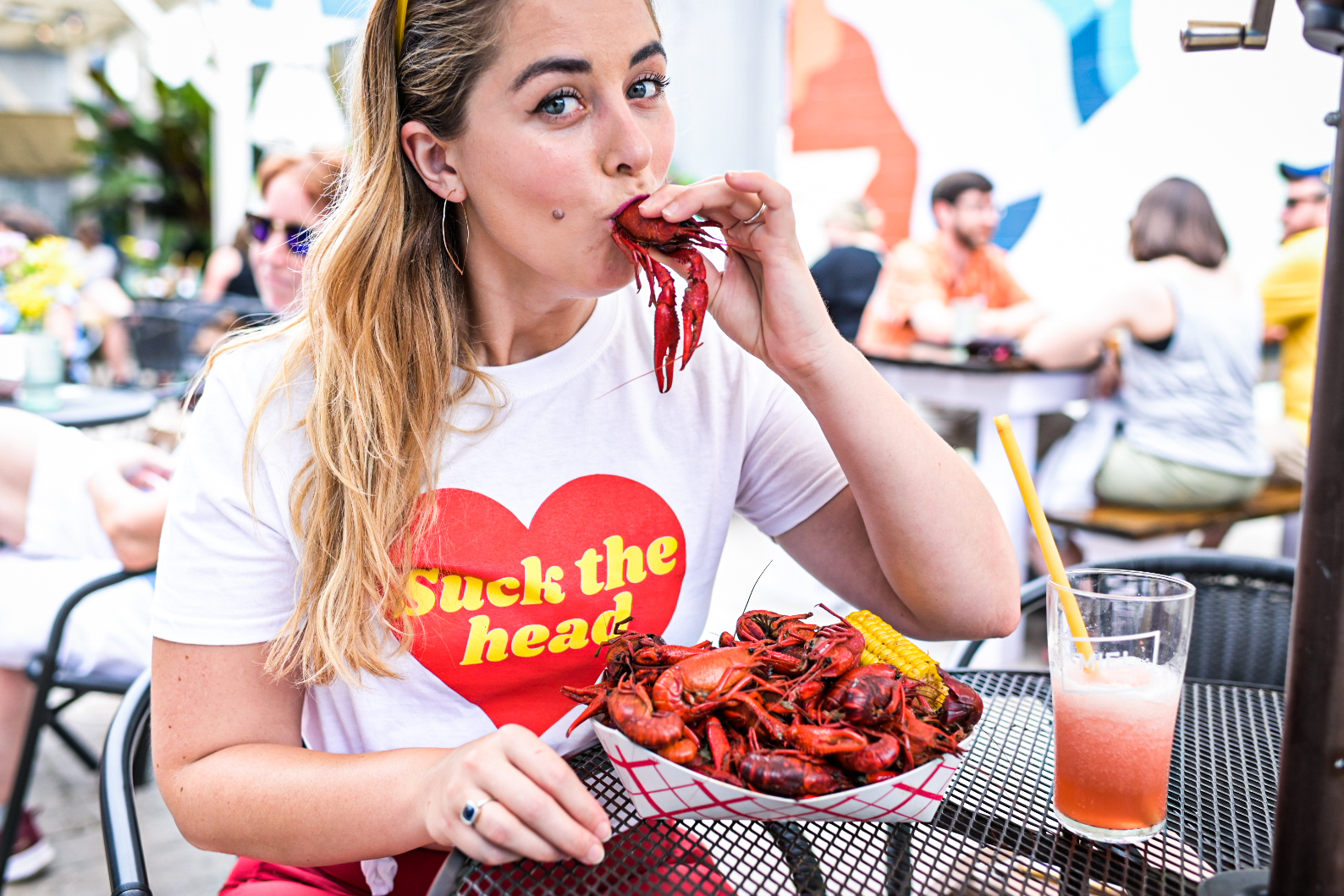 Rémy Robert sucks the head of a crawfish while modeling a t-shirt from Dee Taylor