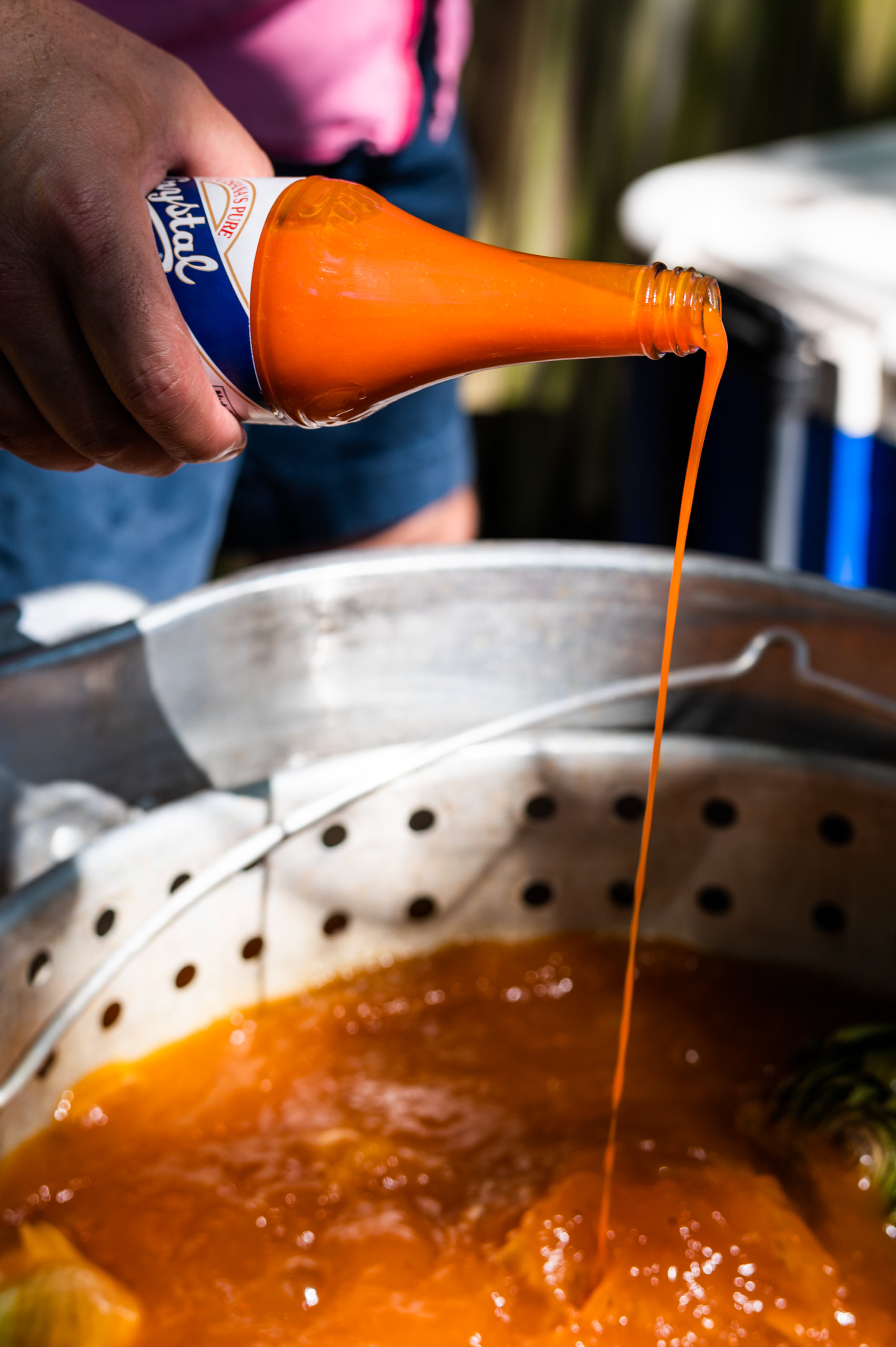 Crystal Hot Sauce is poured into the crawfish boil