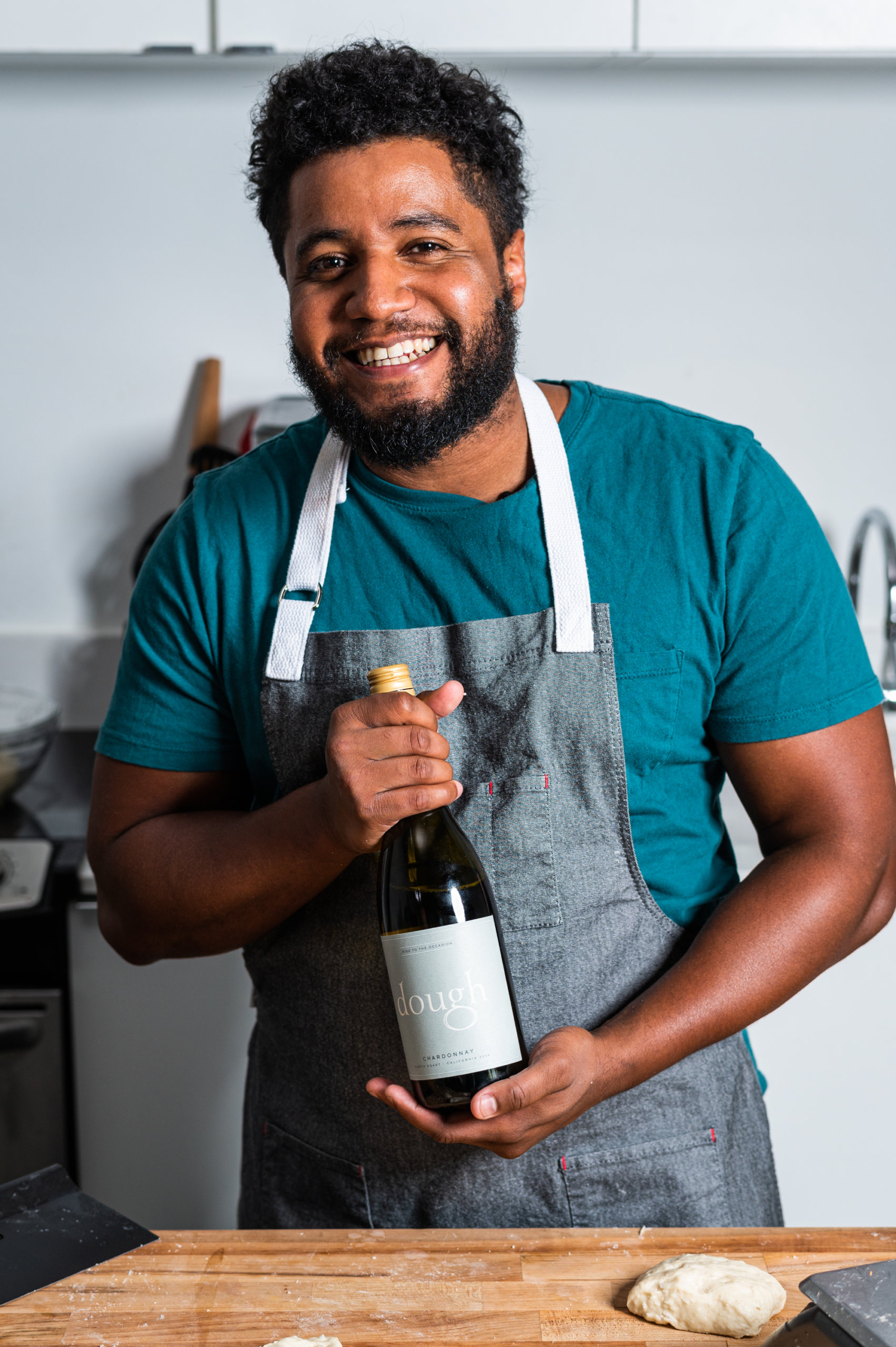Bryan Ford poses in his kitchen with a bottle of Dough Wines