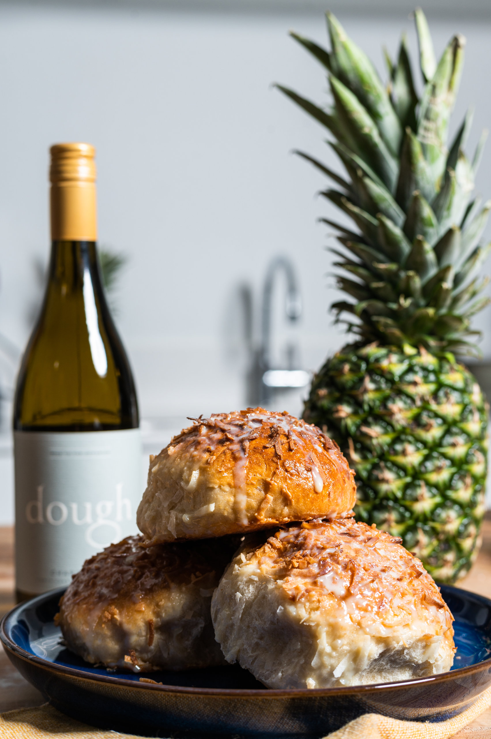 Bryan Ford's pan de coco on display with a bottle of Dough Wines chardonnay and a fresh pineapple