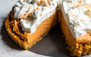Thai tea cream pie with whipped cream and coconut on a corn flake crust