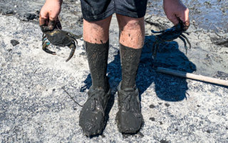 A young child shows off muddy ankles and a crabs following storm the surge from Hurricane Ida