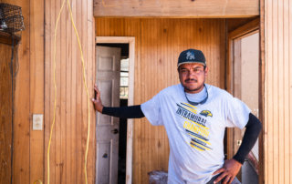 Luis Armendariz stands in the hallway of his home after Hurricane Ida tore his roof off