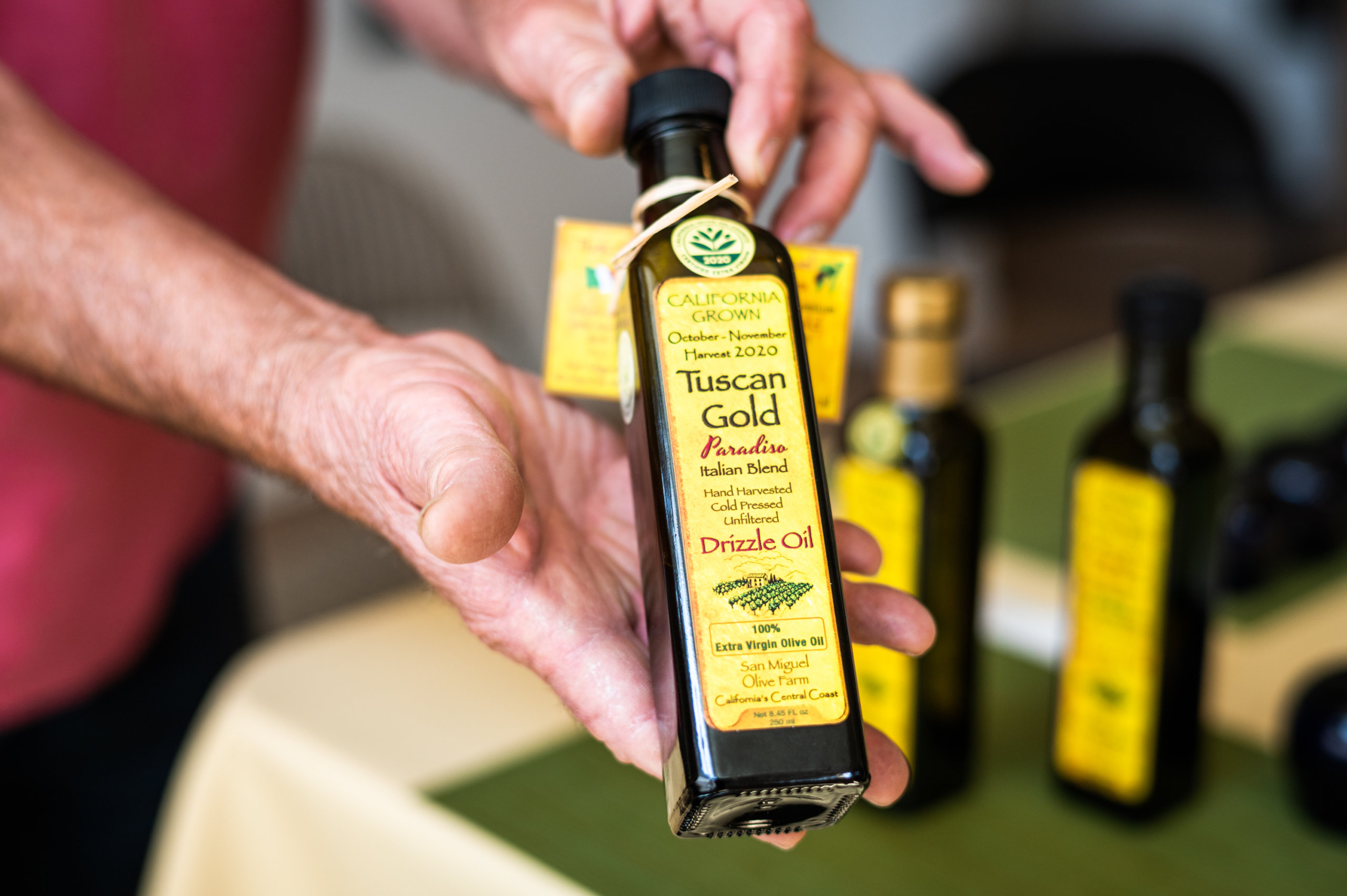 Richard Meisler shows off a bottle of his Tuscan Gold olive oil