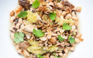 Plated photograph of black-eyed peas with salsa verde and crispy pork