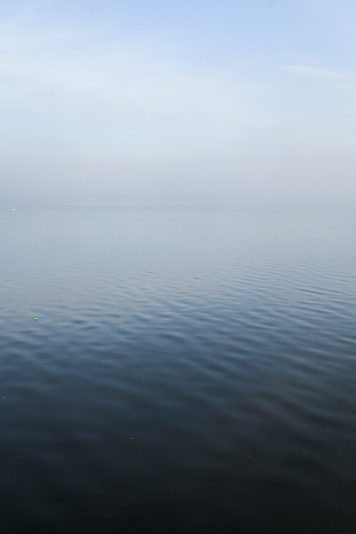 Blurry lines between early morning sky, dense fog, and calm water