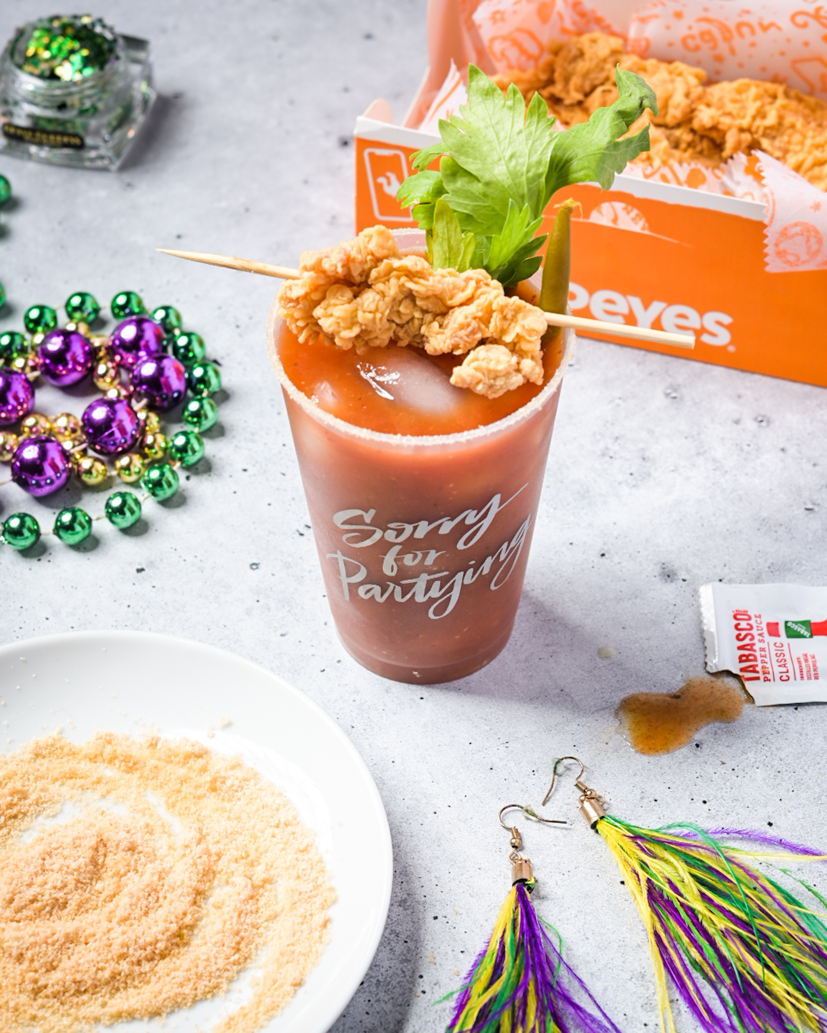 A Bloody Mardi with a Tabasco salt rim and a skewer of Popeye's chicken strips