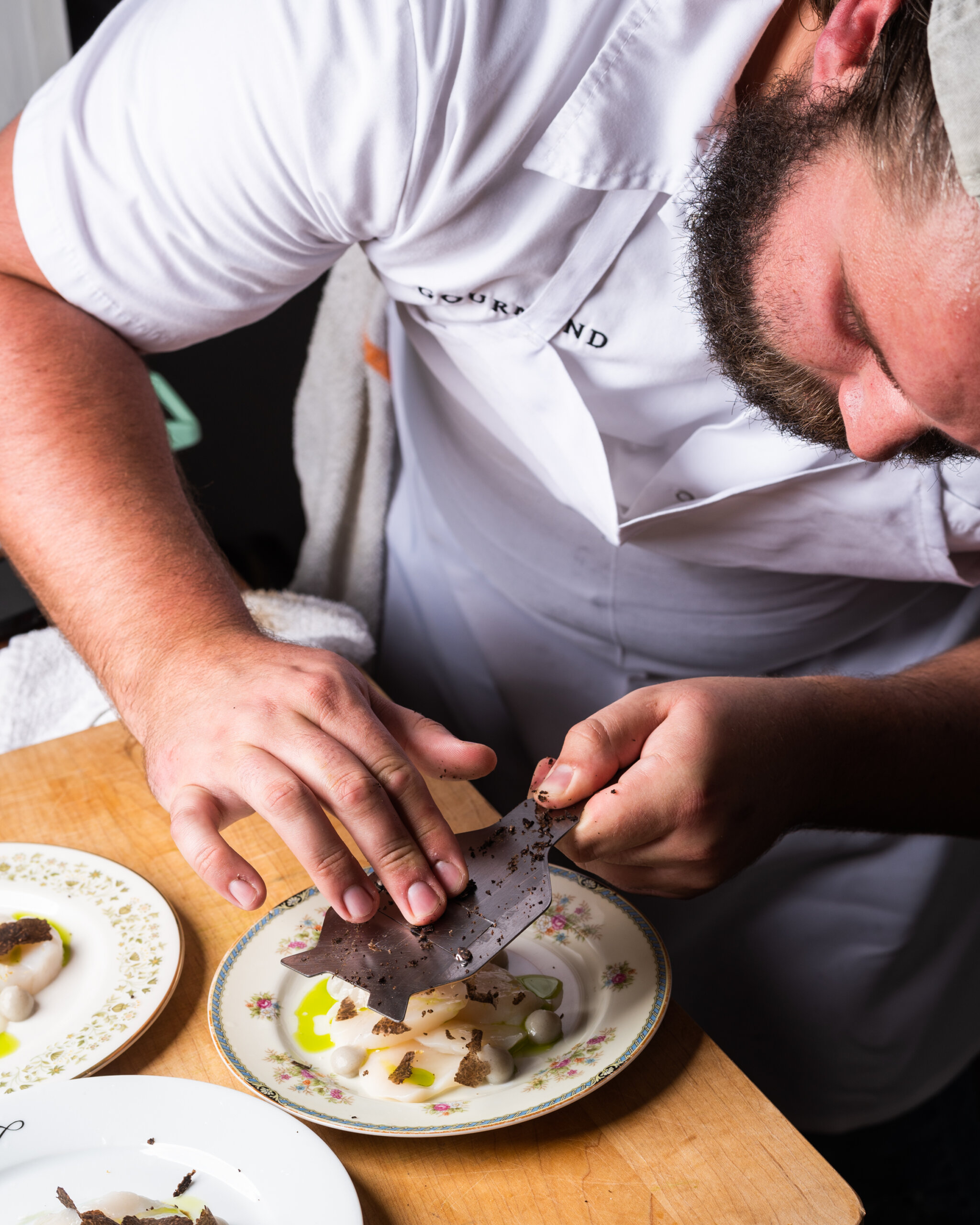 Chef Peyton Barrell of Gourmand shaves fresh truffles over scallop crudo