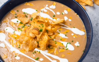 Sarah DiGregorio's recipe for cauliflower and white bean soup with a drizzle of sour cream and a garnish of potato chips