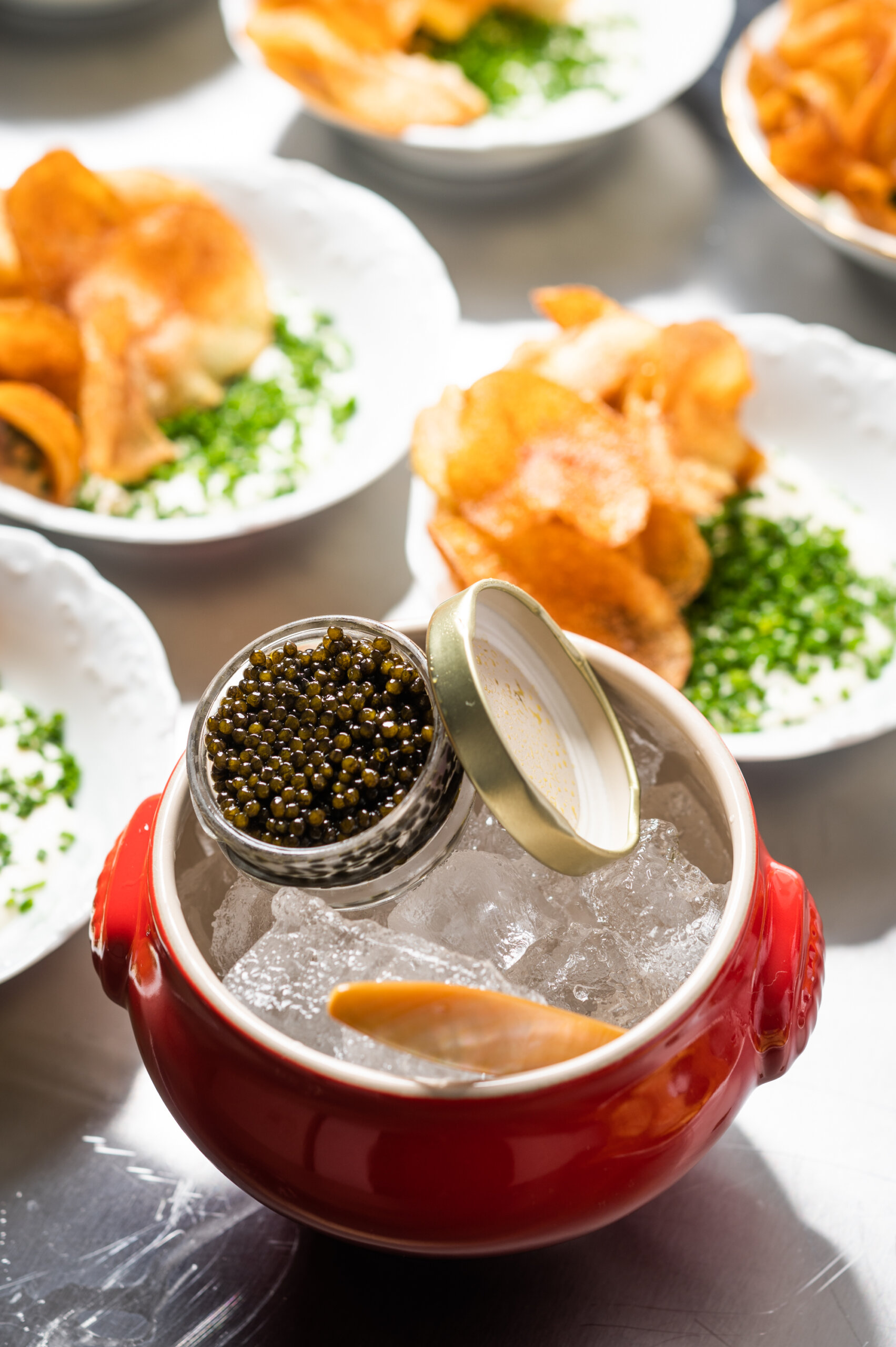 A tin of caviar for potato chips with creme fraiche and chives