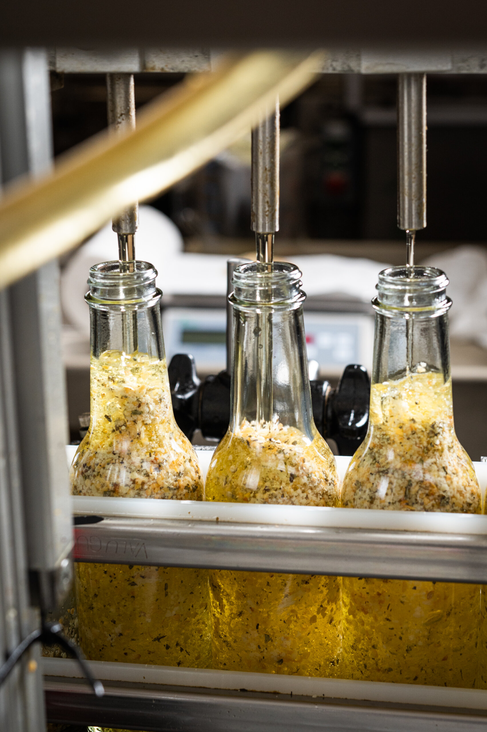 Oil is injected into bottles filled with parmesan and herbs