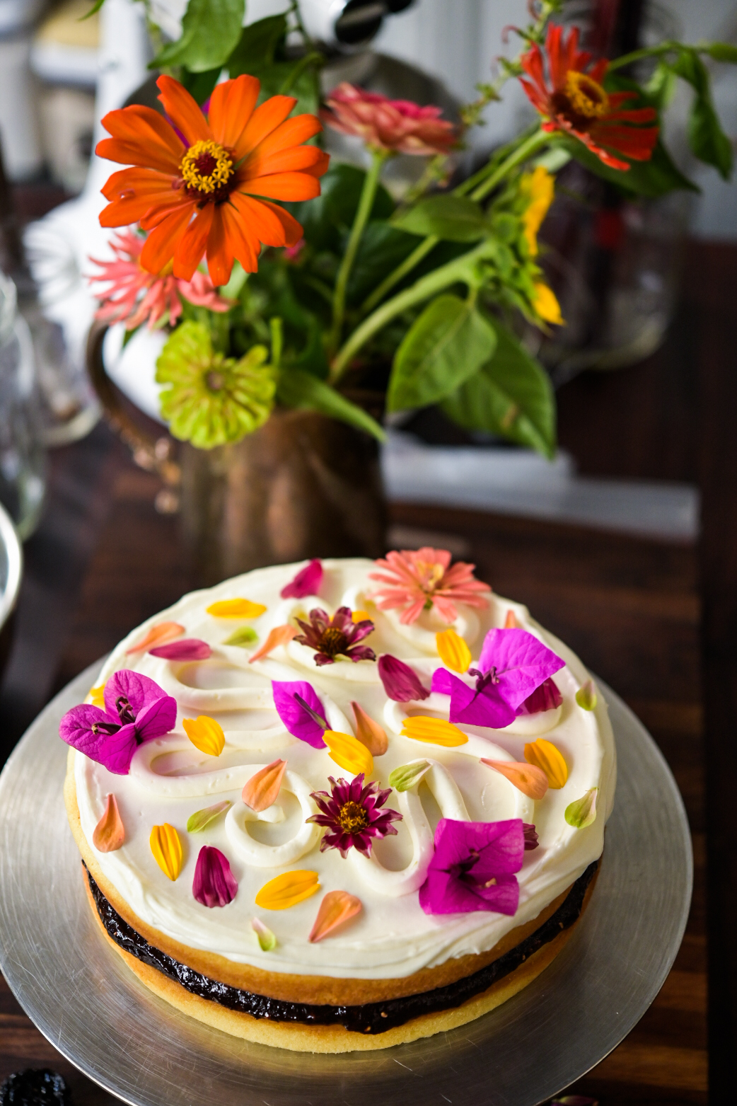 An olive oil cake with prune jam and fresh flowers from Bayou Saint Cake