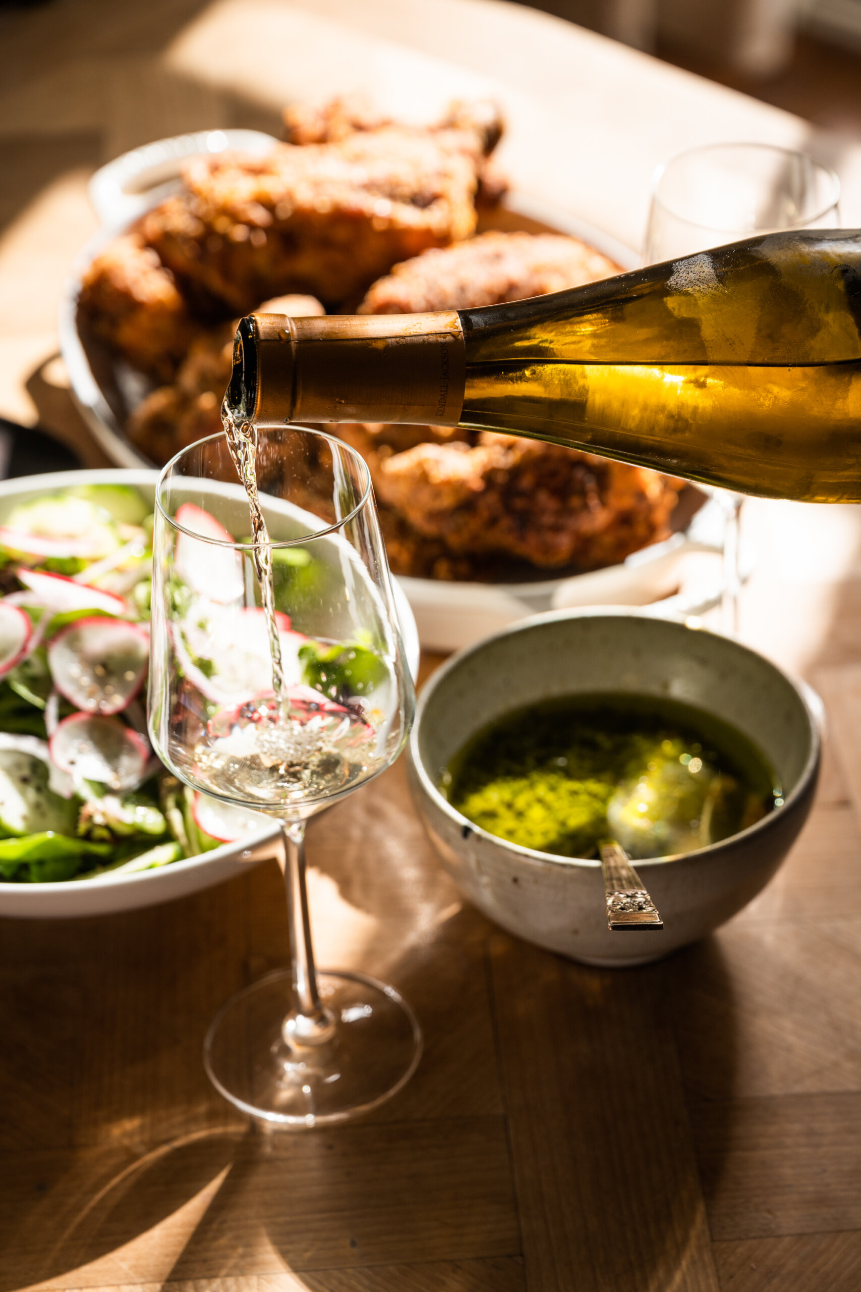 A glass of California chardonnay is poured for pairing with fried chicken
