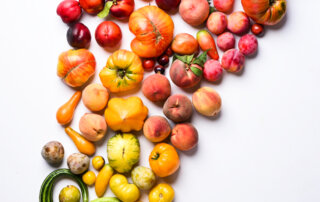 A color gradient of heirloom tomatoes, stone fruit, Armenian cucumbers, and peppers grown by Balakian Farms