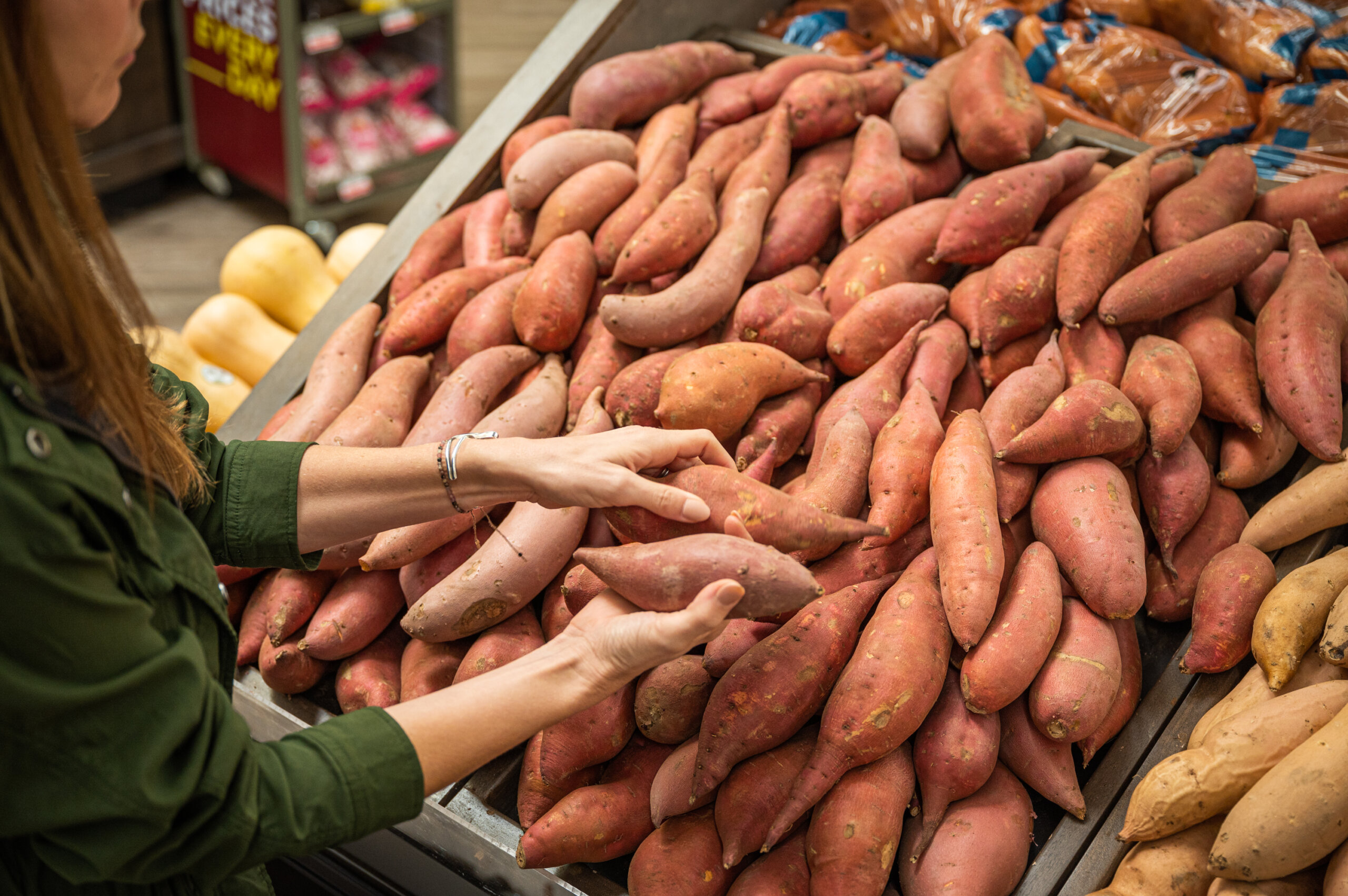 A customer shopping for sweet potatoes grown in California