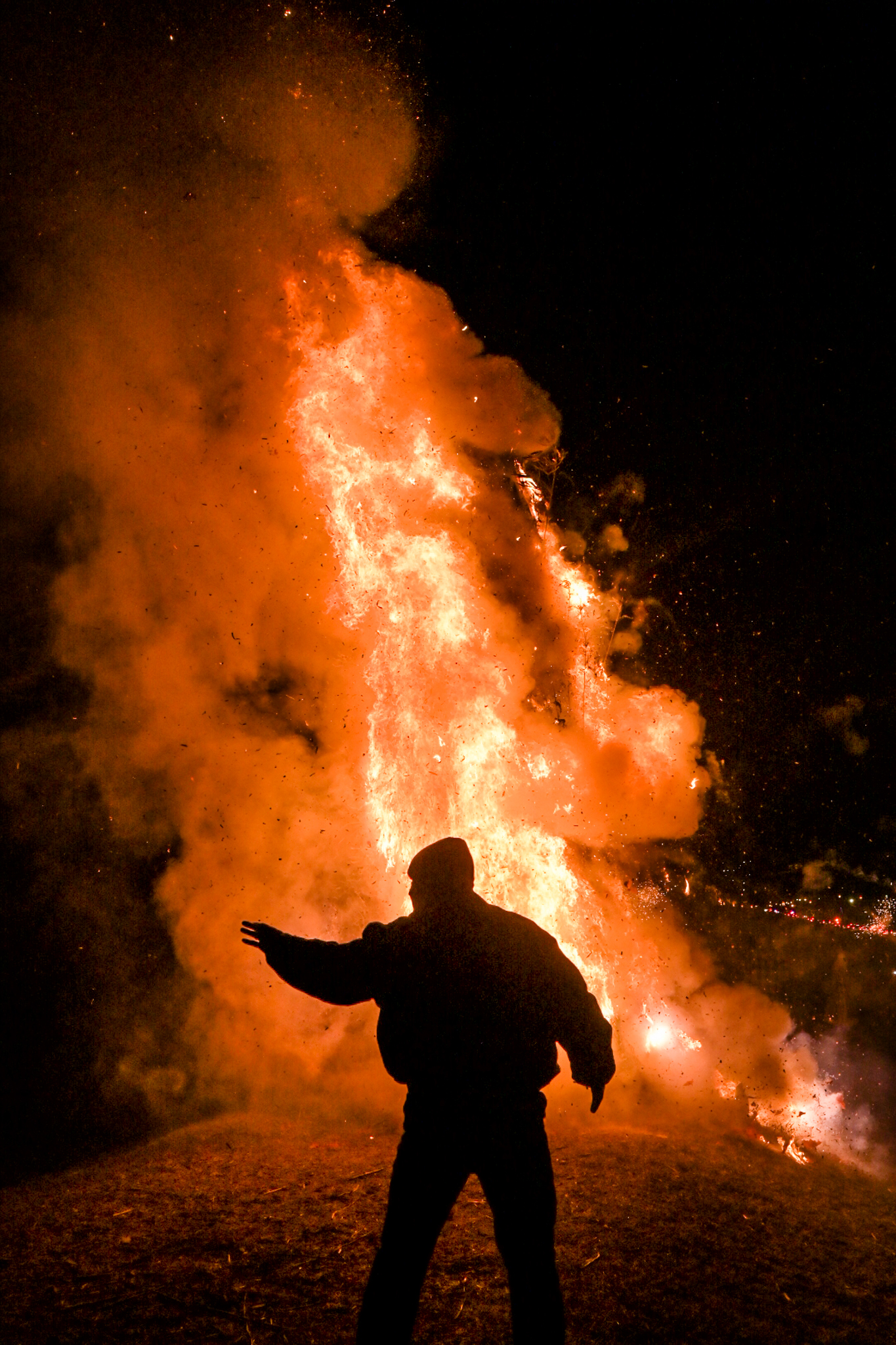 A man stands in front of a large bonfire on the levee in Grammercy, Louisiana