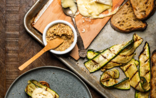 A spread of grilled toasts with zucchini and melted brie