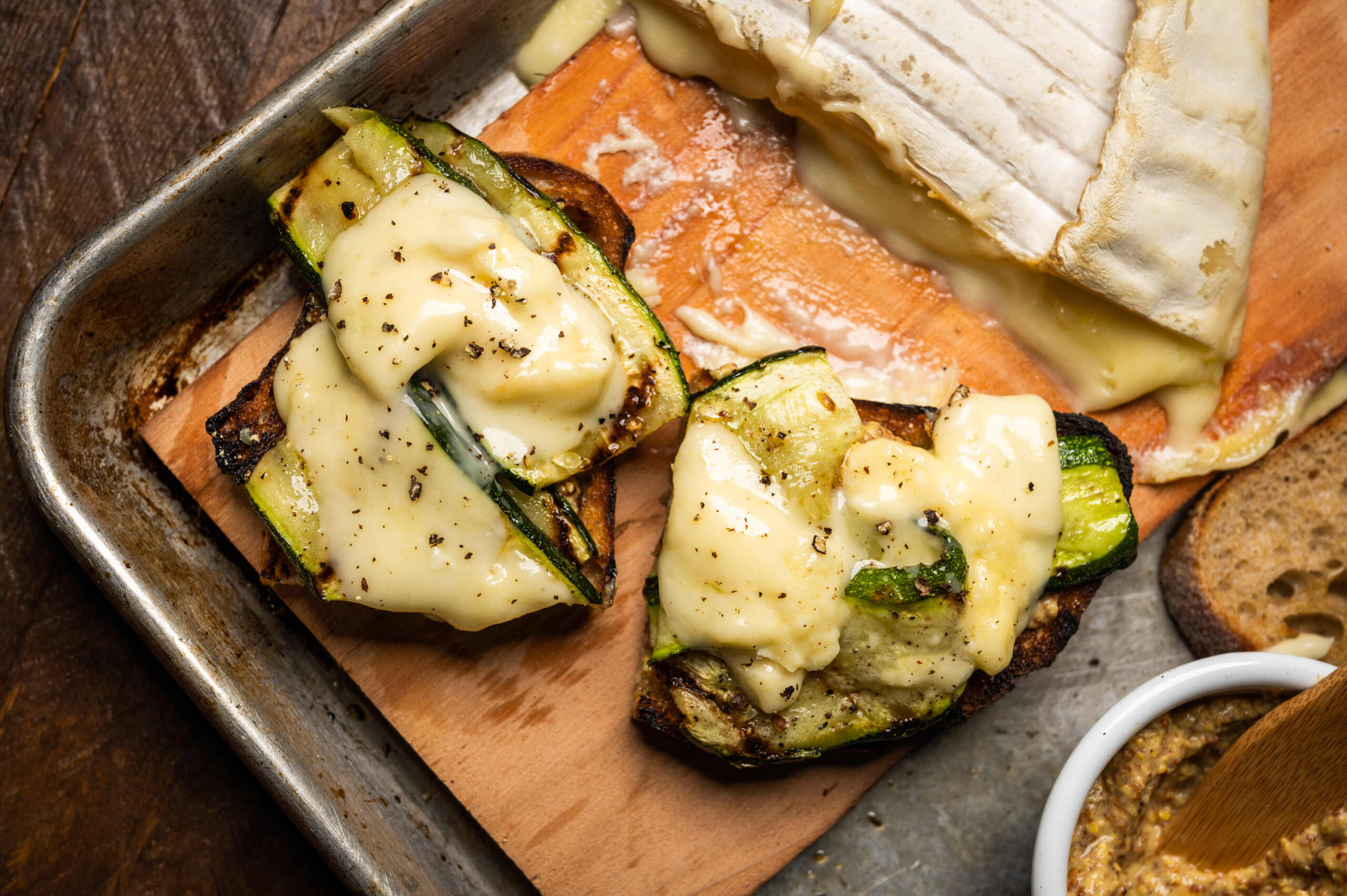 Close-up of melted brie over grilled zucchini and sourdough toast